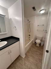 Bathroom featuring visible vents, a textured ceiling, toilet, and vanity