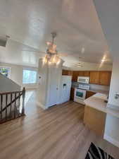 Kitchen featuring a sink, a textured ceiling, ceiling fan, and white appliances