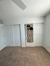 Unfurnished bedroom featuring baseboards, a textured ceiling, ceiling fan, and carpet