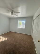 Unfurnished bedroom with carpet floors, baseboards, a closet, and ceiling fan