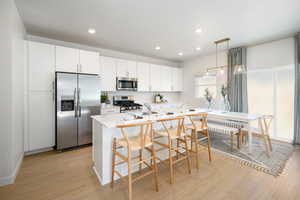 Kitchen featuring light countertops, stainless steel appliances, recessed lighting, and light wood-style floors
