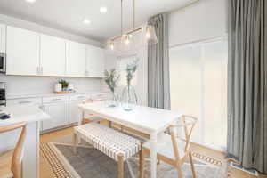 Kitchen featuring visible vents, light countertops, white cabinets, light wood-style floors, and recessed lighting