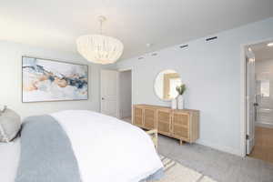 Bedroom with baseboards, a notable chandelier, carpet, and visible vents