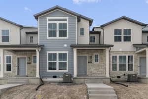 Townhome / multi-family property with central AC and stone siding
