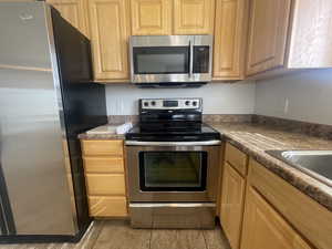 Kitchen with stainless steel appliances and light tile patterned flooring