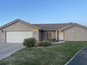 Ranch-style house featuring an attached garage, stucco siding, a tiled roof, and concrete driveway
