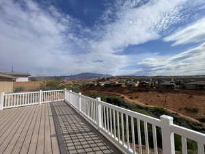Wooden deck featuring a residential view, fence, and a mountain view