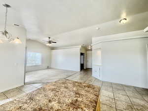 Unfurnished room with visible vents, lofted ceiling, baseboards, ceiling fan, and light tile patterned floors