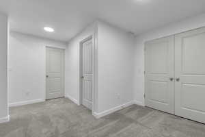 Unfurnished bedroom with baseboards, carpet, and a closet
