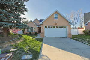Ranch-style house featuring brick siding, stucco siding, a front yard, and fence