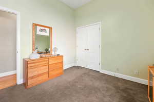 Bedroom with baseboards and dark carpet