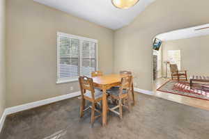 Dining area with baseboards, vaulted ceiling, and carpet floors