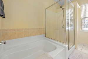 Bathroom with a bath, a shower stall, and tile patterned flooring