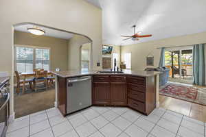 Kitchen featuring ceiling fan, appliances with stainless steel finishes, arched walkways, a sink, and open floor plan