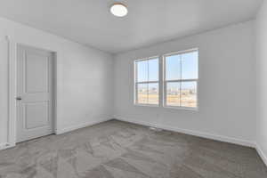 Carpeted empty room with baseboards and visible vents