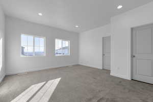Carpeted spare room featuring visible vents, recessed lighting, and baseboards