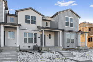 View of front of home featuring brick siding and cooling unit