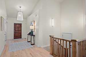 Foyer featuring high vaulted ceiling, baseboards, and light wood-style floors
