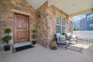 View of exterior entry featuring a mountain view, a porch, and stone siding