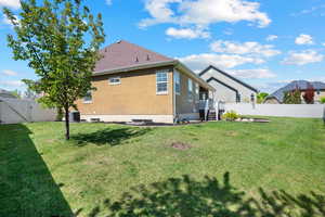 Rear view of property featuring a fenced backyard, stucco siding, a gate, central air condition unit, and a yard