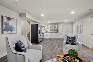 Living room with recessed lighting, visible vents, wood finished floors, and stairway