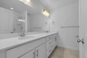 Full bath featuring a sink, a shower with door, double vanity, and visible vents