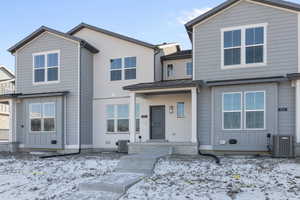 View of front of house featuring a standing seam roof and central AC