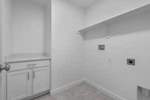 Laundry area with washer hookup, electric dryer hookup, light colored carpet, cabinet space, and baseboards