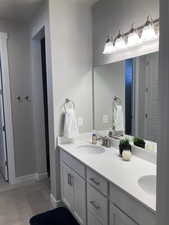 Full bathroom with a sink, double vanity, and wood finished floors