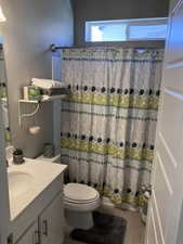 Bathroom featuring vanity, toilet, and a shower with shower curtain