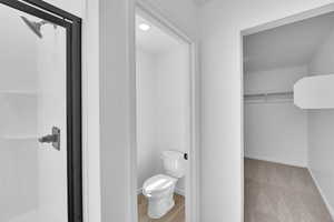 Bathroom featuring toilet, baseboards, and a shower