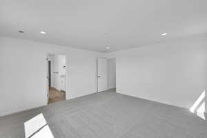 Interior space featuring connected bathroom, carpet, recessed lighting, baseboards, and visible vents