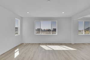 Empty room featuring baseboards, recessed lighting, wood finished floors, and visible vents