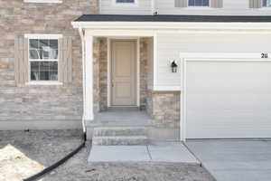 Entrance to property featuring stone siding