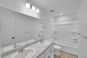 Bathroom featuring a sink, shower / bathing tub combination, and visible vents
