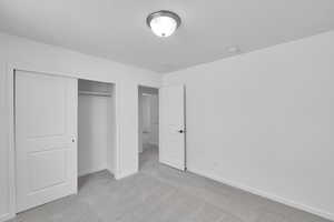 Unfurnished bedroom with carpet flooring, baseboards, and a closet