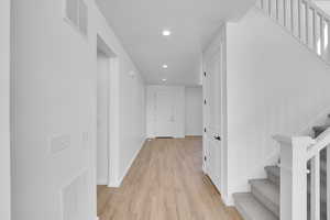 Corridor with visible vents, recessed lighting, light wood-style floors, and stairway