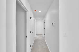 Hall featuring recessed lighting, baseboards, and light colored carpet
