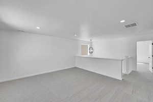 Carpeted spare room featuring baseboards, recessed lighting, a textured ceiling, and visible vents