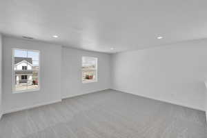 Unfurnished room with a healthy amount of sunlight, visible vents, recessed lighting, and light colored carpet