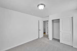 Unfurnished bedroom featuring baseboards, carpet, and a closet