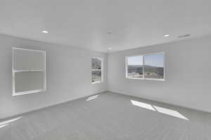 Empty room with carpet flooring, baseboards, and visible vents