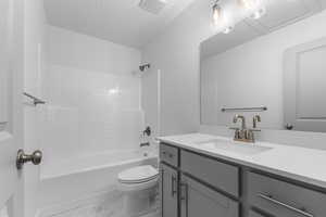 Full bath with shower / tub combination, vanity, toilet, marble finish floor, and visible vents