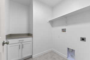 Laundry area with baseboards, cabinet space, electric dryer hookup, and hookup for a washing machine