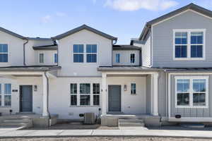 View of front of home featuring brick siding, central AC, a standing seam roof, and metal roof
