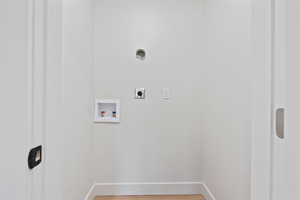 Clothes washing area featuring electric dryer hookup, hookup for a washing machine, baseboards, and laundry area