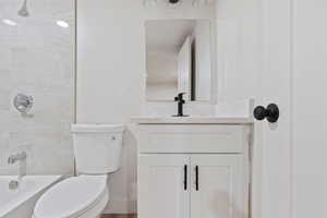 Bathroom with vanity, baseboards, toilet, and  shower combination