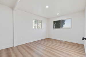 Empty room with baseboards, light wood finished floors, and recessed lighting