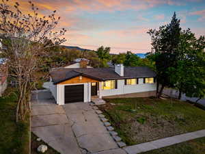 Single story home with driveway, a chimney, a lawn, a garage, and fence