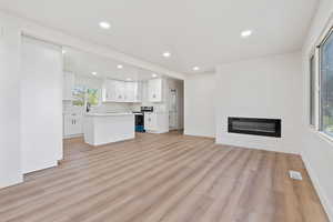 Unfurnished living room featuring recessed lighting, light wood-type flooring, and visible vents